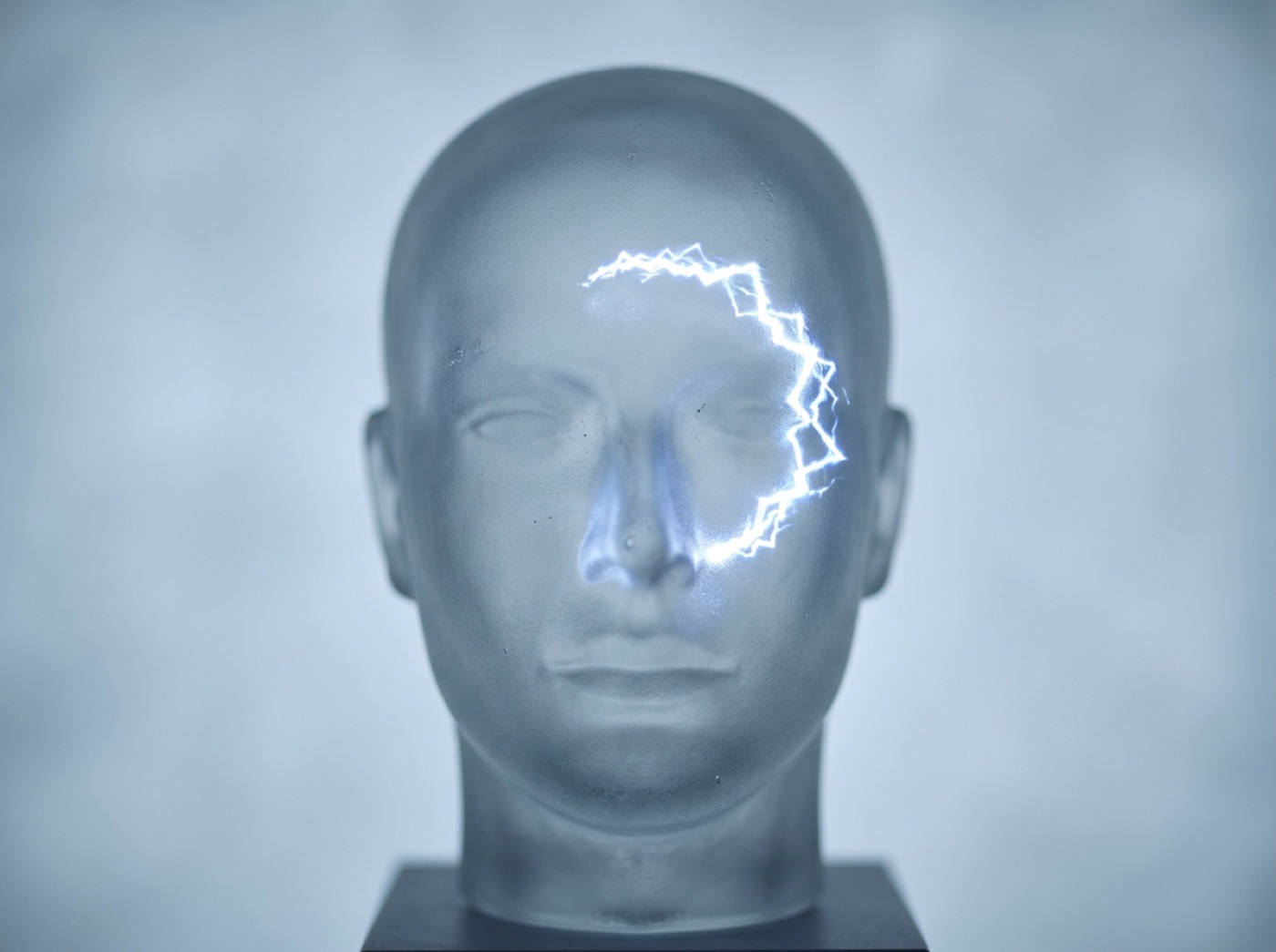 A glass head with a shimmering zigzag arc of light in front of one eye